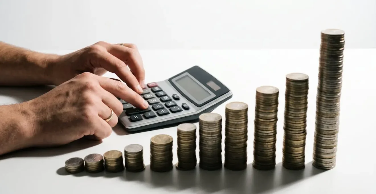 Personne calculant ses mensualités avec calculatrice et documents flous